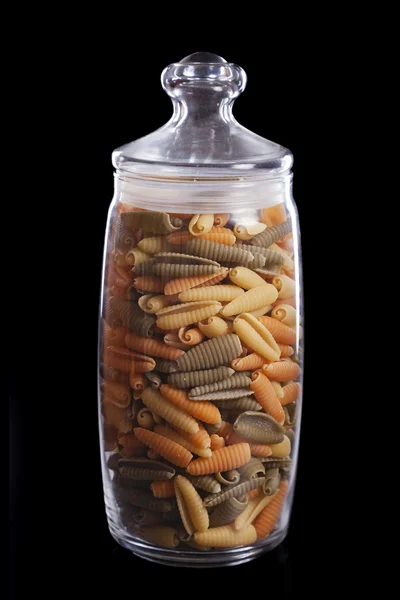 Spaghetti schelpen in de glazen pot geïsoleerd op zwart — Stockfoto