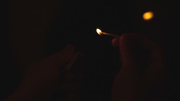 allumette brûlante dans la main de l'homme sur fond noir 