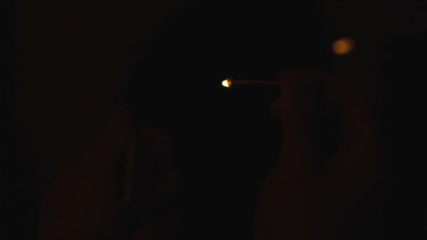 Brinnande tändsticka i mannens hand på svart bakgrund — Stockvideo