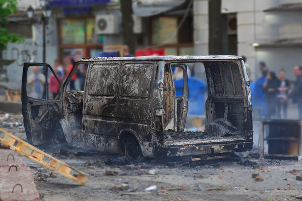 Burned car in the center of city after unrest 
