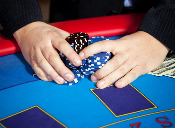 Hand with chips, and $ banknotes on table — Stock Photo, Image