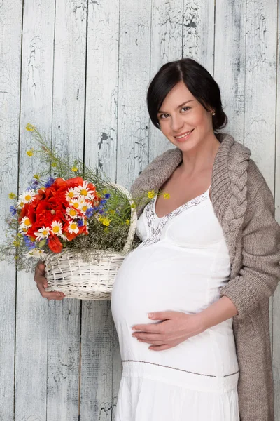 妊娠中の花を持つ女性 — ストック写真