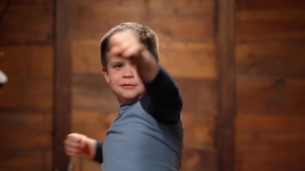 Un copil drăguţ boxează cu braţele şi picioarele. Copilul învață să lupte. 4k de înaltă calitate — Videoclip de stoc