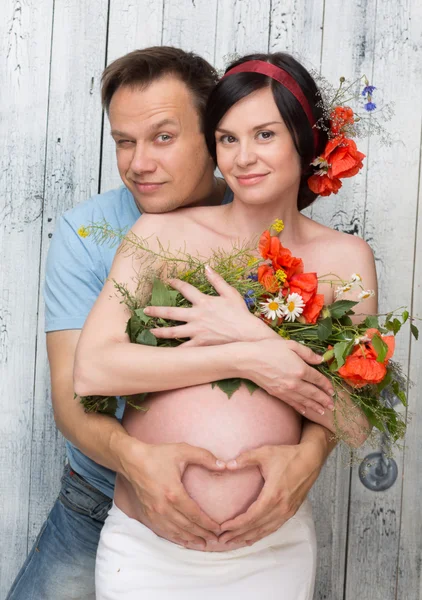Gravid kvinna med man och blommor — Stockfoto