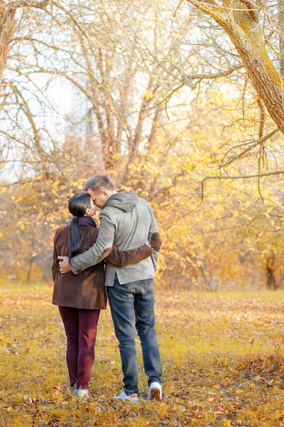 Pareja caucásica de otoño de pie cara a cara en un parque lleno de sol. Estilo casual en colores otoñales. De larga duración. Fondo de Fall Park —  Fotos de Stock