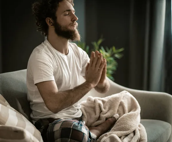 Um homem forte em Pajamas tem a sua meditação. Meditação habitual no início do dia. Close-up — Fotografia de Stock