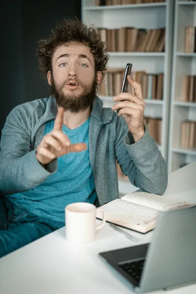 Empresário tem um telefonema muito importante e pede para ficar quieto. O homem tem uma chamada importante no trabalho. Close-up. Prateleiras de livros Fundo — Fotografia de Stock