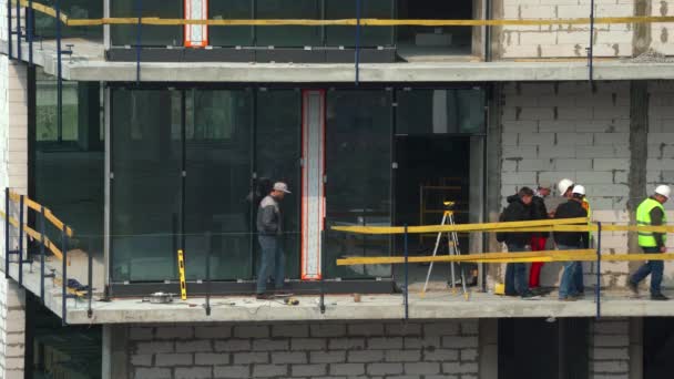 Capataz del sitio lleva a cabo la supervisión de las obras de construcción. Foreman organiza los trabajos de construcción de un edificio inacabado de gran altura. Kiev, Ucrania 18 de abril de 2020 Videoclip