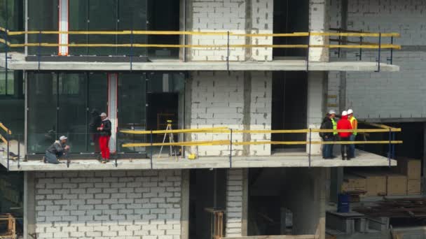 Construction Foreman tiene una riunione per il team di costruzione, Piano di lavoro per una giornata lavorativa in un cantiere. Primo piano. Kiev, Ucraina - 18 aprile 2020 Filmato Stock Royalty Free