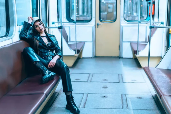 Mujer joven caucásica triste regresa de una fiesta nocturna en el último tren del metro a medianoche. Sexy hembra sentada relajada en el asiento en un vagón vacío del metro. Primer plano —  Fotos de Stock