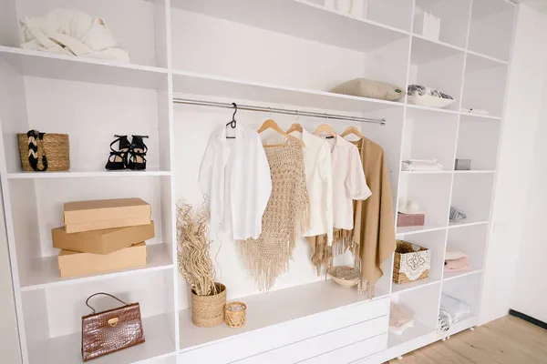 Female Fashionable Stylish Wardrobe. A Large White Built-in Wardrobe Stocked With Womens Clothing, Shoes and Accessories. Walk-in closet, Dressing Room for Women