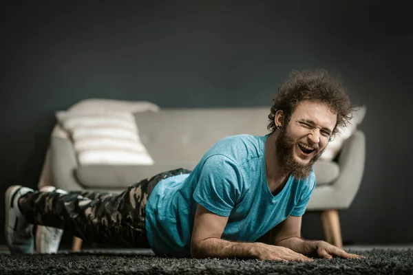 Lata killen tar hand om de sista sekunderna. Lazy Man gör Plank med roligt ansikte. Medium närbild — Stockfoto