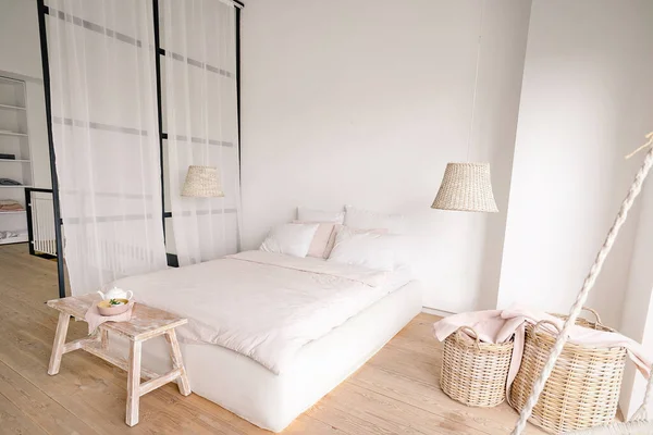 Bleka rosa sovrum i en minimalistisk stil med en dubbelsäng med områden för kläder och för sovande — Stockfoto