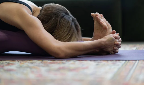 Woman Practices Yoga Asanas in Morning for Energy για όλη την ημέρα. Γιόγκα Lady κάνει καθιστή εμπρός κάμψης άσκηση πρόσωπο προς τα κάτω. Κοντινό πλάνο — Φωτογραφία Αρχείου