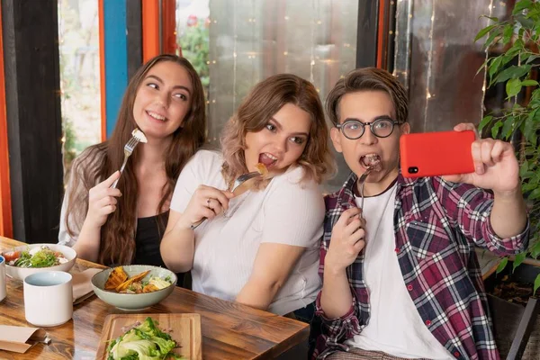 Förstaårselever på ett café tar en selfie. Tonårsvänner träffas för lunch. Första årets studerande tillbringar fritid tillsammans. — Stockfoto