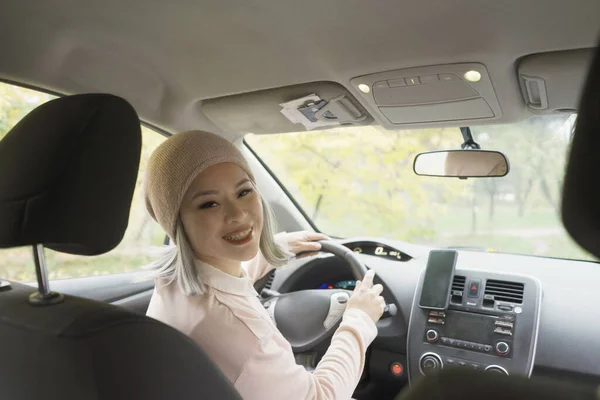 Angry asian woman showing middle finger or fuck leaning out the car window.  Mature asian woman