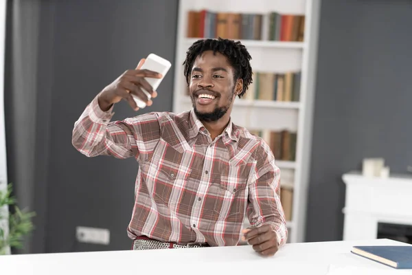 Jeune étudiant afro-américain utiliser smartphone ayant appel vidéo ou de prendre selfie. Portrait de l'homme heureux gestuelle regardant la caméra du smartphone. Concept de médias sociaux — Photo