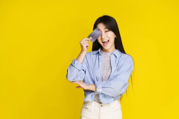 Chica Asiática Feliz Sosteniendo Crédito Tarjeta Débito Tocando Cara Ojo — Foto de Stock