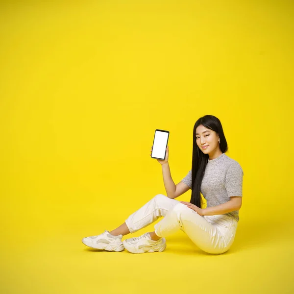Charming Asian Young Girl Holding Smartphone Sitting Floor Showing White — Stock Photo, Image