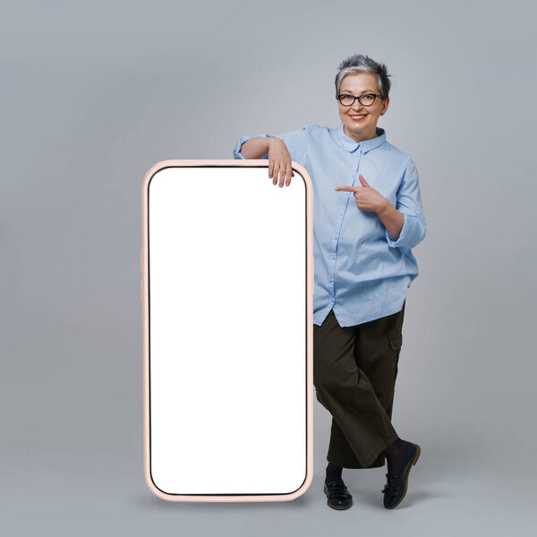 Mature Grey Hair Woman Pointing Finger Screen Giant Huge Smartphone Stock Photo
