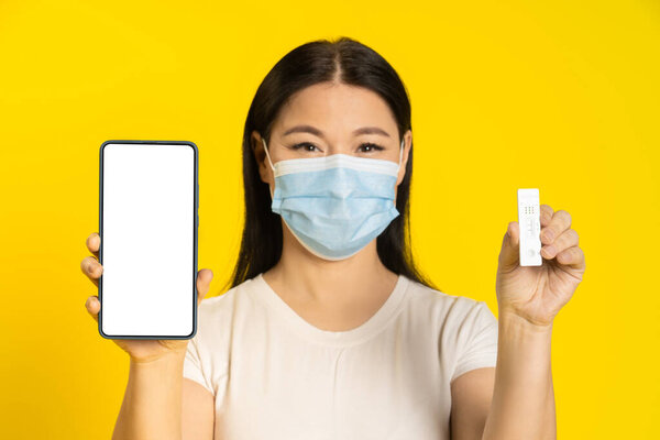 Happy Asian Woman Wearing Medical Face Mask Holding Smartphone Test Royalty Free Stock Images