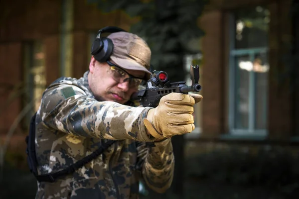 Shotgun weapon action course. Private military contractor at tactical training course. Shooter with a gun in military uniform. Police training in shooting gallery with weapon. Outdoor shooting range.