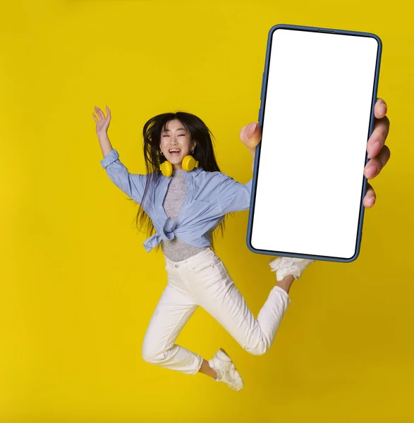 Щаслива Стрибає Азіатська Дівчина Смартфоном Руці Показуючи Рекламу Мобільного Додатку — стокове фото
