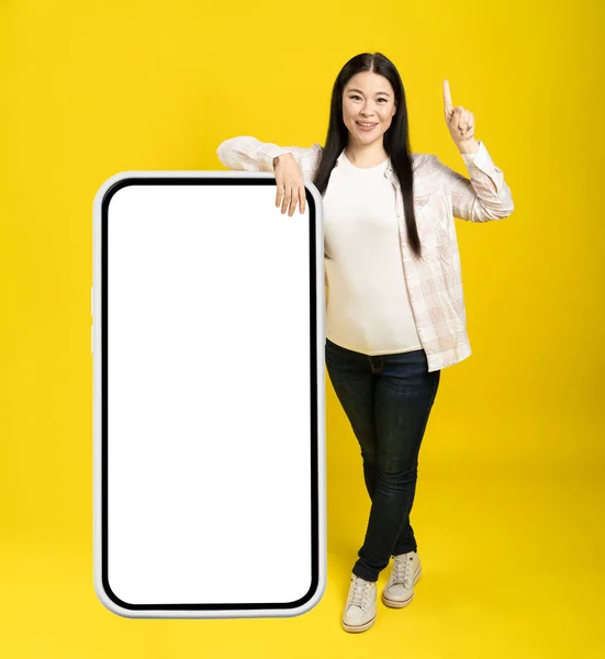 Азійська Жінка Вказує Пальцем Один Увага Прикута Гігантського Величезний Смартфон — стокове фото