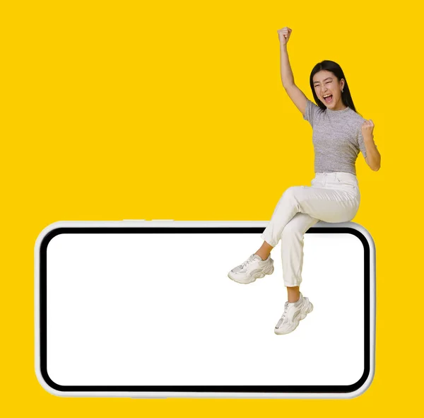 Excited Hands Lifted Victory Asian Girl Sitting Giant Huge Smartphone — Stock Photo, Image
