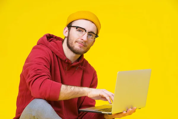 Junger Hipster Mann Sitzt Mit Laptop Roten Kapuzenpulli Auf Dem — Stockfoto