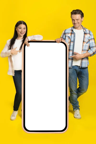 Pointing White Screen Caucasian Man Asian Woman Standing Leaned Huge —  Fotos de Stock