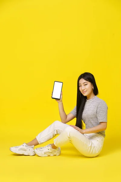 Charming Asian Young Girl Holding Smartphone Sitting Floor Showing Black — Photo