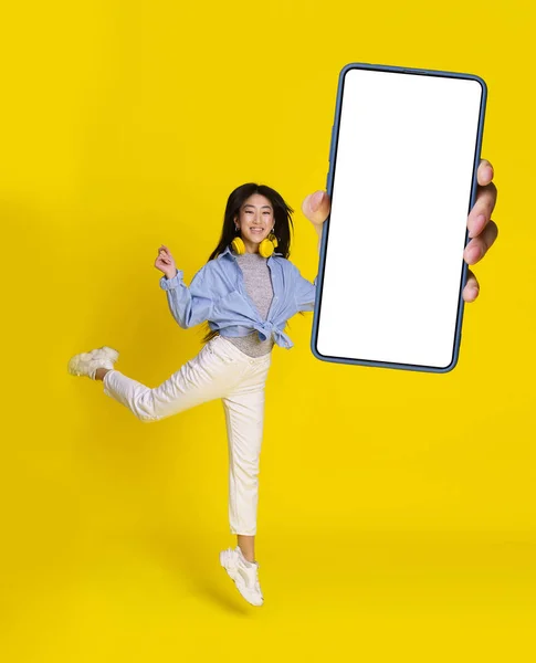 Мобільний Додаток Чудова Пропозиція Стрибки Азіатської Дівчини Великим Смартфоном Руці — стокове фото