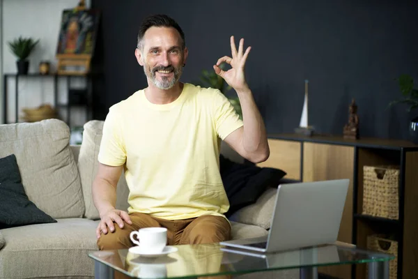 Gesto Sonriente Hombre Mediana Edad Sentado Sofá Sofá Beber Café — Foto de Stock