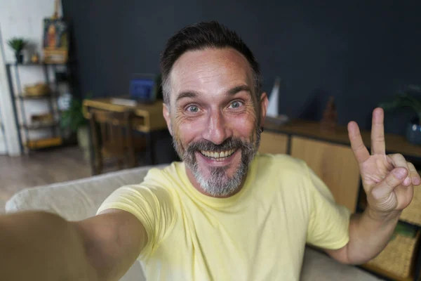 Gesturing Kemenangan Mengambil Selfie Menggunakan Smartphone Duduk Sofa Sofa Rumah — Stok Foto