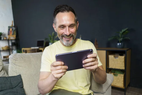 Evdeki Kanepede Gündelik Kıyafetlerle Dijital Tablet Kullanan Orta Yaşlı Gri — Stok fotoğraf