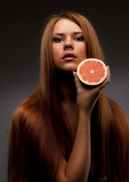 Portret van mooie vrouw met grapefruit — Stockfoto