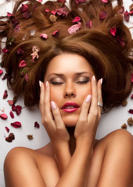 Schöne junge Frau mit wallenden Haaren und Blumen — Stockfoto