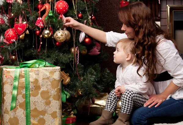 Gelukkig moeder kerstboom versieren met haar baby — Stockfoto