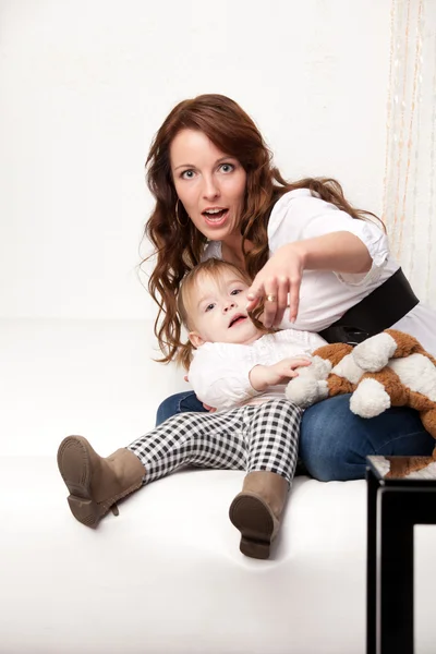 Young mother showing on something — Stock Photo, Image