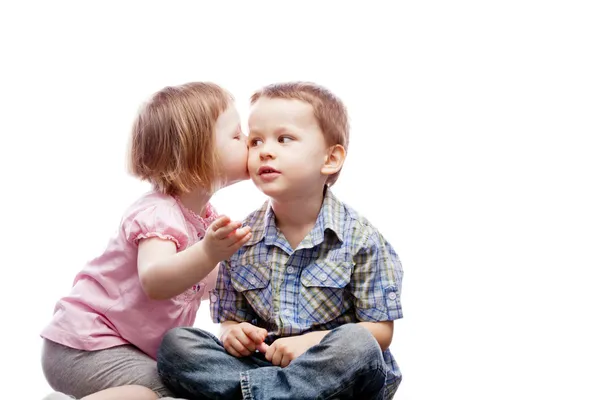 Kleines Mädchen küsst ihren älteren Bruder auf die Wange - isoliert — Stockfoto