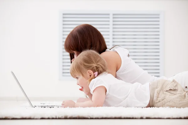 Moeder met dochter op zoek op de laptop — Stockfoto