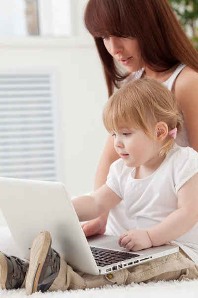 Liefdevolle familie op zoek naar een laptop Stockafbeelding