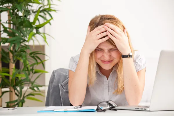 Kvinna med huvudvärk sitter vid bordet — Stockfoto