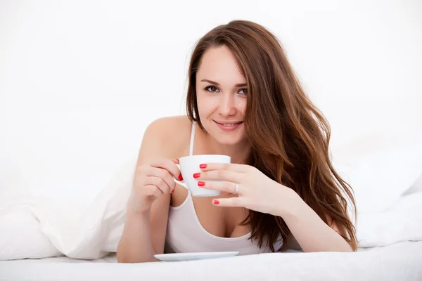 Frau im Bett trinkt Tee — Stockfoto