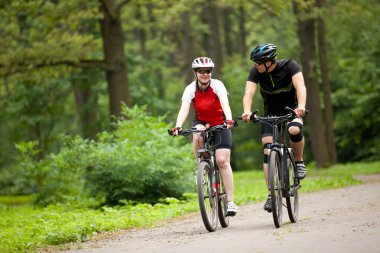 Man and woman riding bicycles clipart