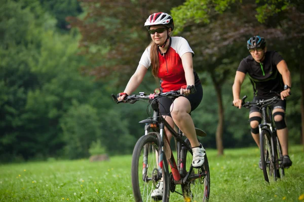 Man och kvinna ridning cyklar — Stockfoto