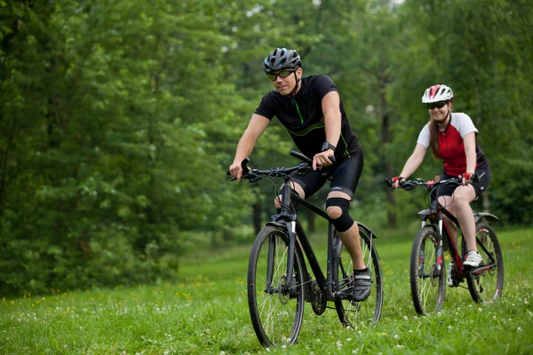 Man and woman riding bicycles — Stock Photo, Image