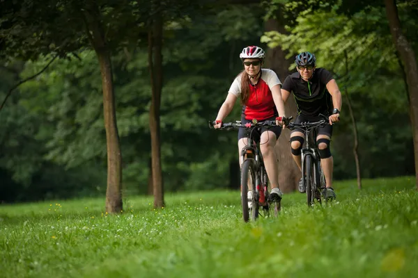 Man och kvinna ridning cyklar — Stockfoto