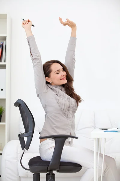 Mujer estirándose en el lugar de trabajo — Foto de Stock